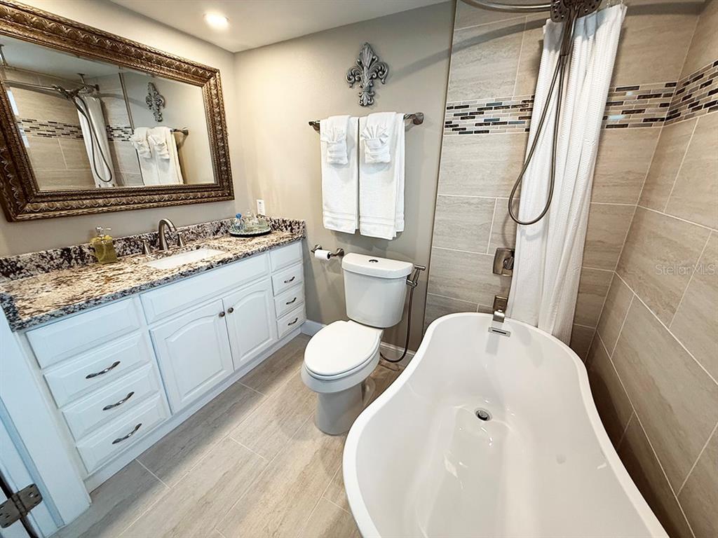 4455 Duhme Road, Unit 103 St. Petersburg, FL 33708 - Photo 19 of 37 a bathroom with a toilet sink and mirror