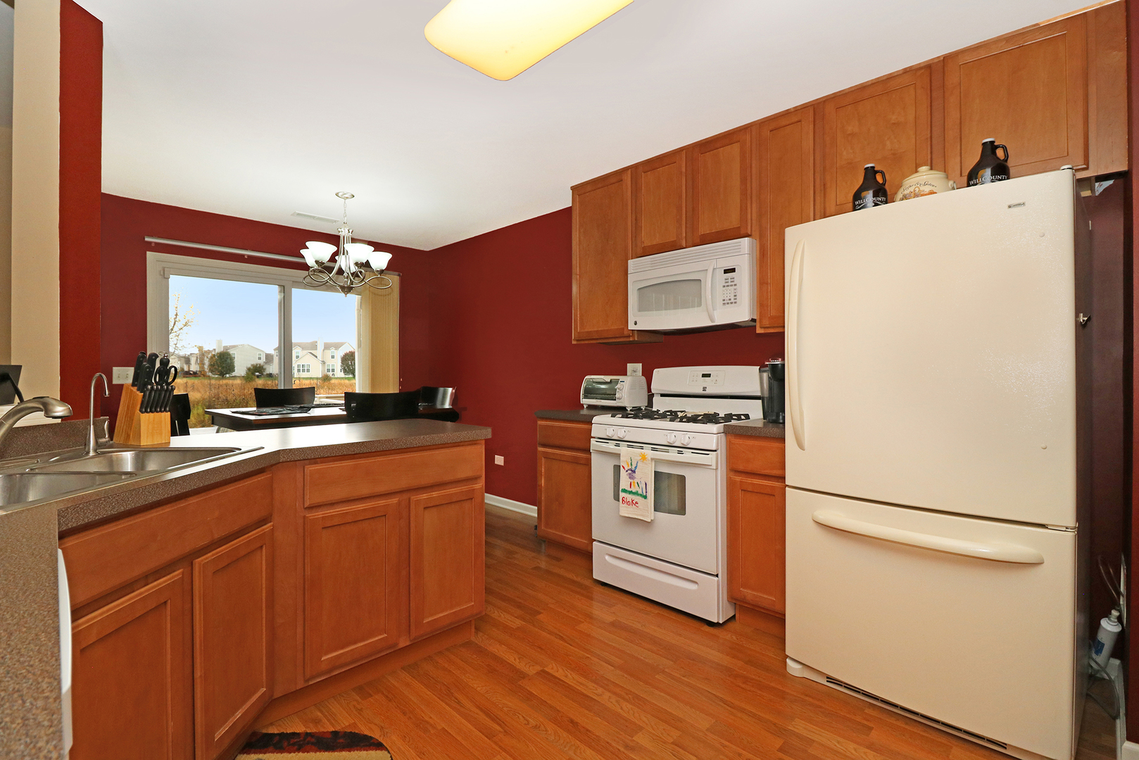 15261 Pinewood Road Lockport, IL 60441 - Photo 8 of 24 a kitchen with white cabinets and white appliances