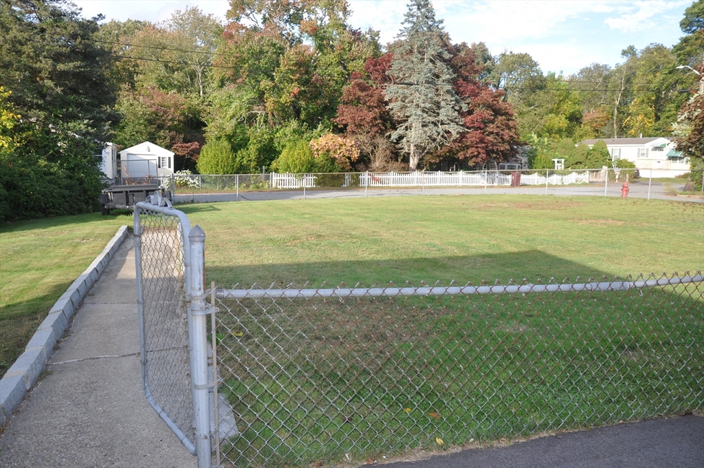 57 Crompton Street Acushnet, MA 02743 - Photo 8 of 21 a view of a pathway both side of building with yard