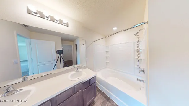 a bathroom with a granite countertop sink a bathtub and a mirror
