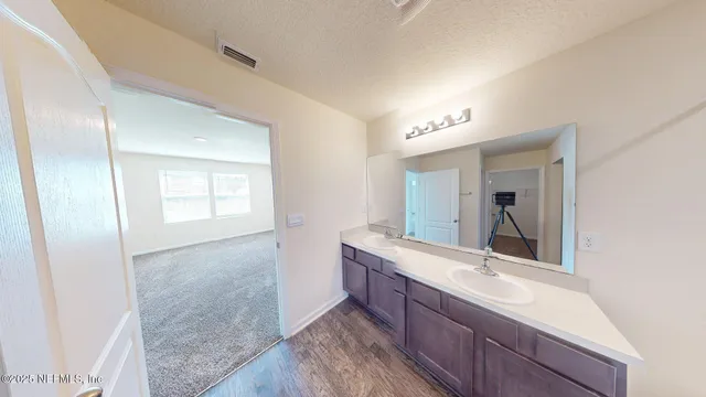 a bathroom with a double vanity sink a mirror and a shower