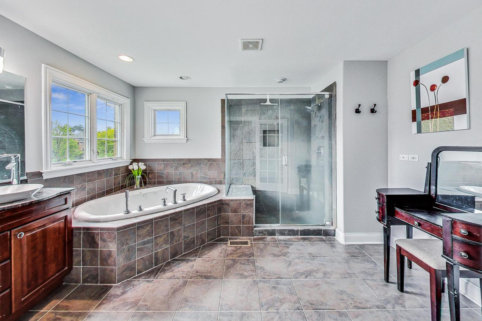321 Forest Drive Addison, IL 60101 - Photo 16 of 35 a spacious bathroom with a tub a sink a mirror and a shower