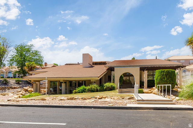 2158 Balboa Way St. George, UT 84770 - Photo 31 of 40 Mediterranean-style building featuring a prominent arched entry, tile roofing, and a decorative pergola