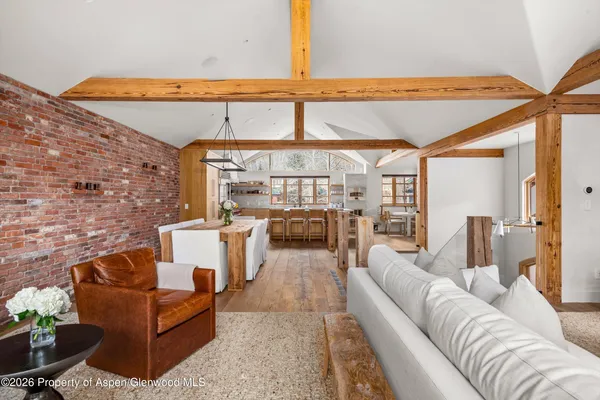 a living room with furniture a rug and a floor to ceiling window