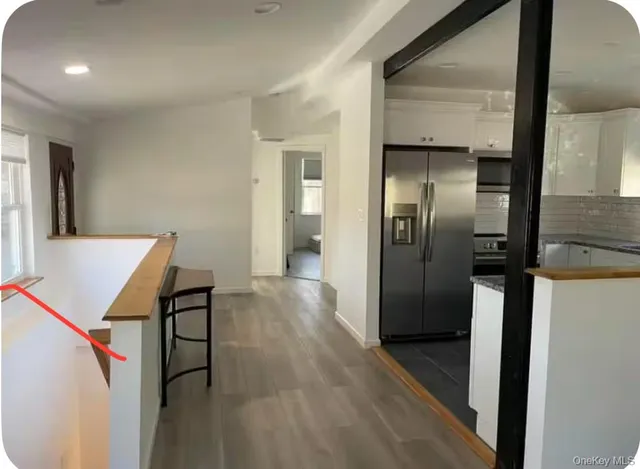 a view of a hallway with wooden floor and staircase