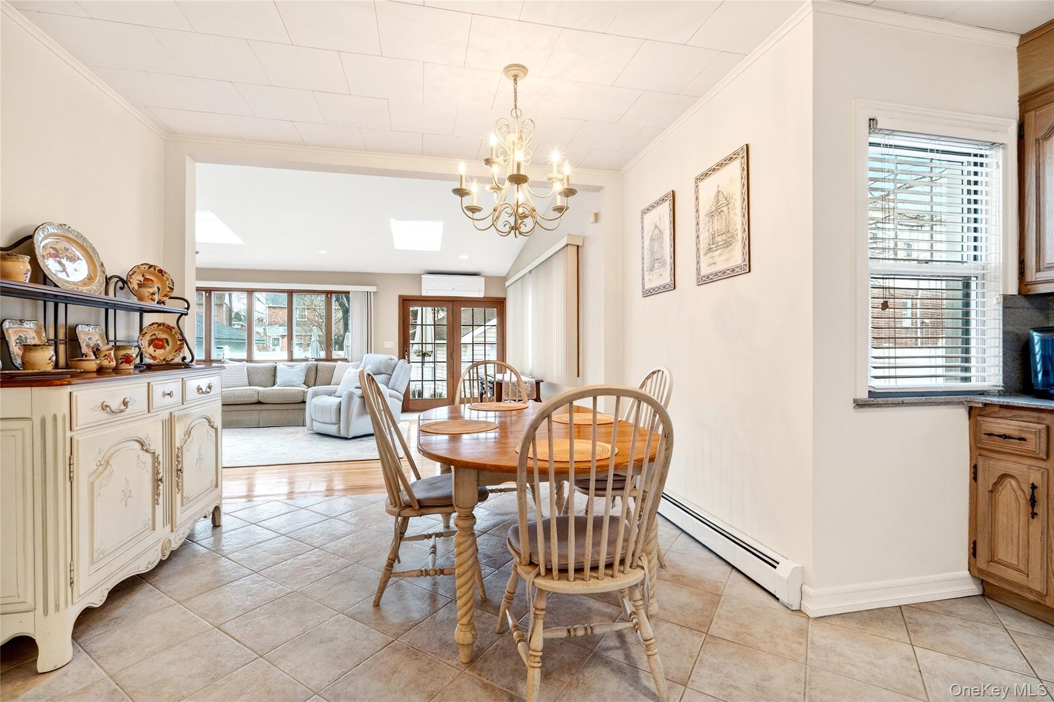 3334 Country Club Road Bronx, NY 10465 - Photo 14 of 49 Dining area featuring a chandelier, light tile patterned floors, ornamental molding, french doors, and a skylight