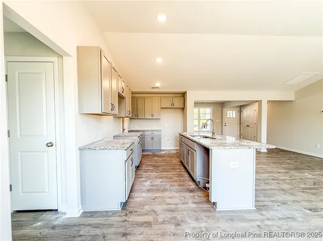 a large kitchen with stainless steel appliances granite countertop a large counter top and a stove top oven