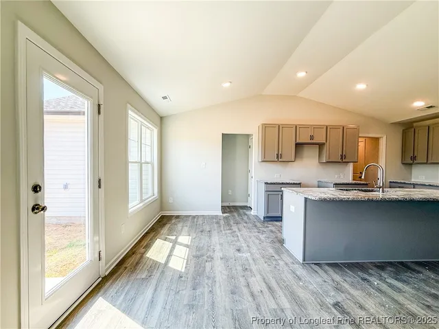 a kitchen with stainless steel appliances granite countertop a stove a sink and a refrigerator