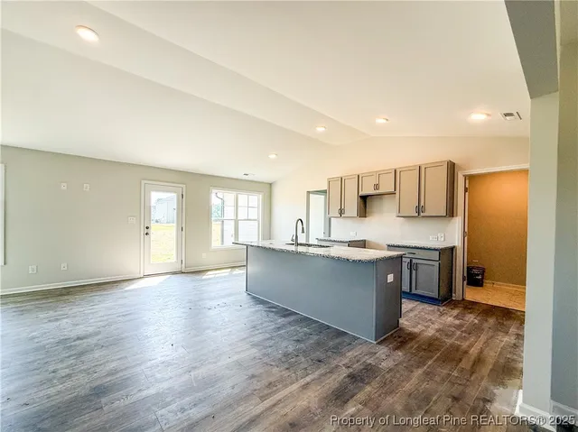 a large kitchen with a lot of counter space and wooden floor