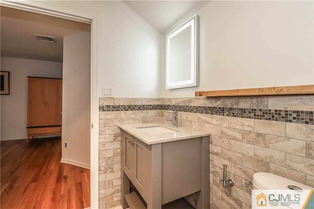4 Southfield Road Edison, NJ 08820 - Photo 25 of 46 a bathroom with a granite countertop sink and a mirror