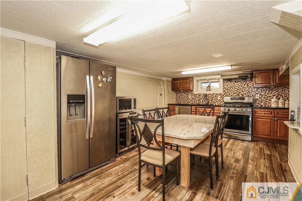 4 Southfield Road Edison, NJ 08820 - Photo 39 of 46 a kitchen with stainless steel appliances kitchen island granite countertop refrigerator dining table and chairs