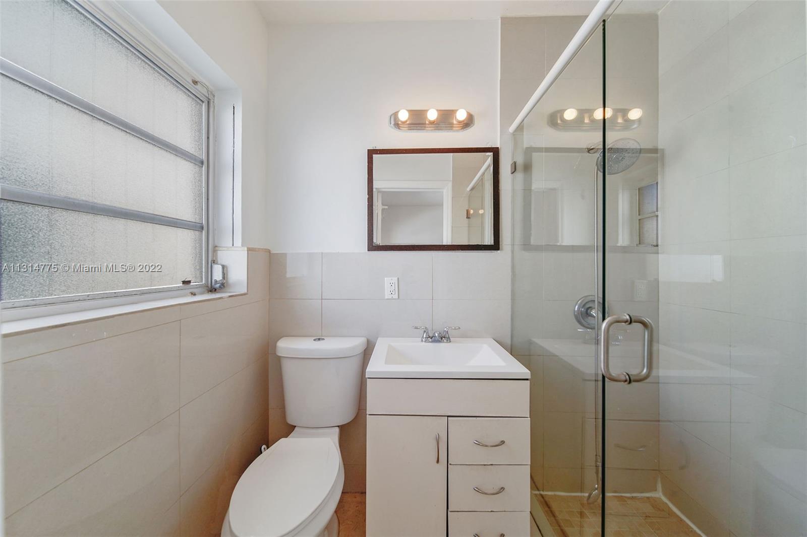9116 Abbott Avenue Surfside, FL 33154 - Photo 15 of 23 a bathroom with a toilet sink and a mirror