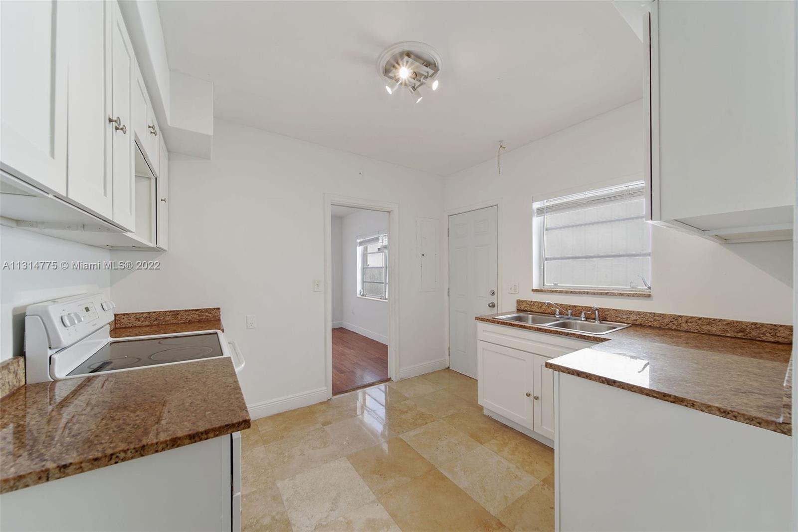 9116 Abbott Avenue Surfside, FL 33154 - Photo 17 of 23 a kitchen with granite countertop a sink stove and cabinets