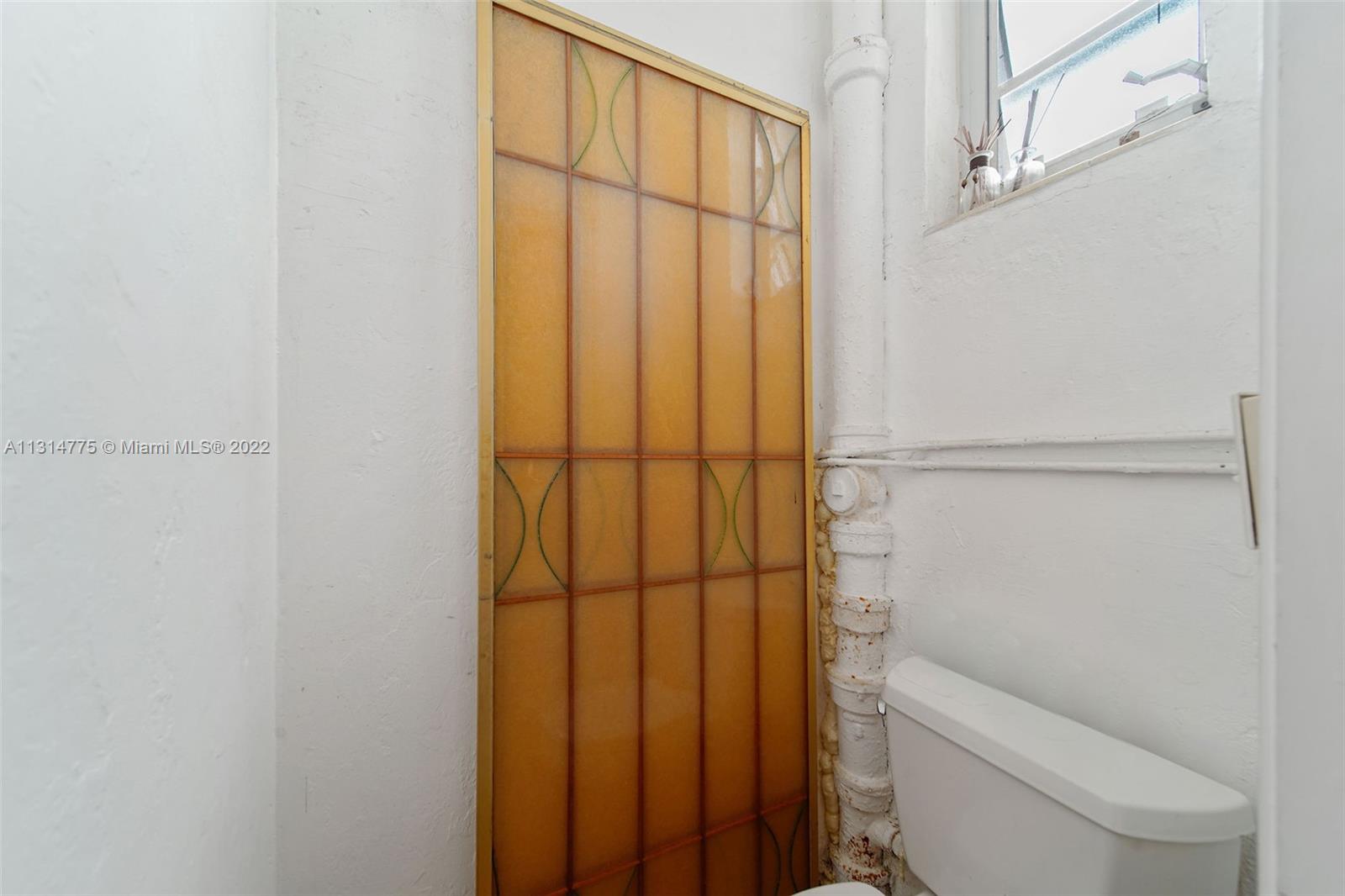 9116 Abbott Avenue Surfside, FL 33154 - Photo 20 of 23 a bathroom with a shower curtain