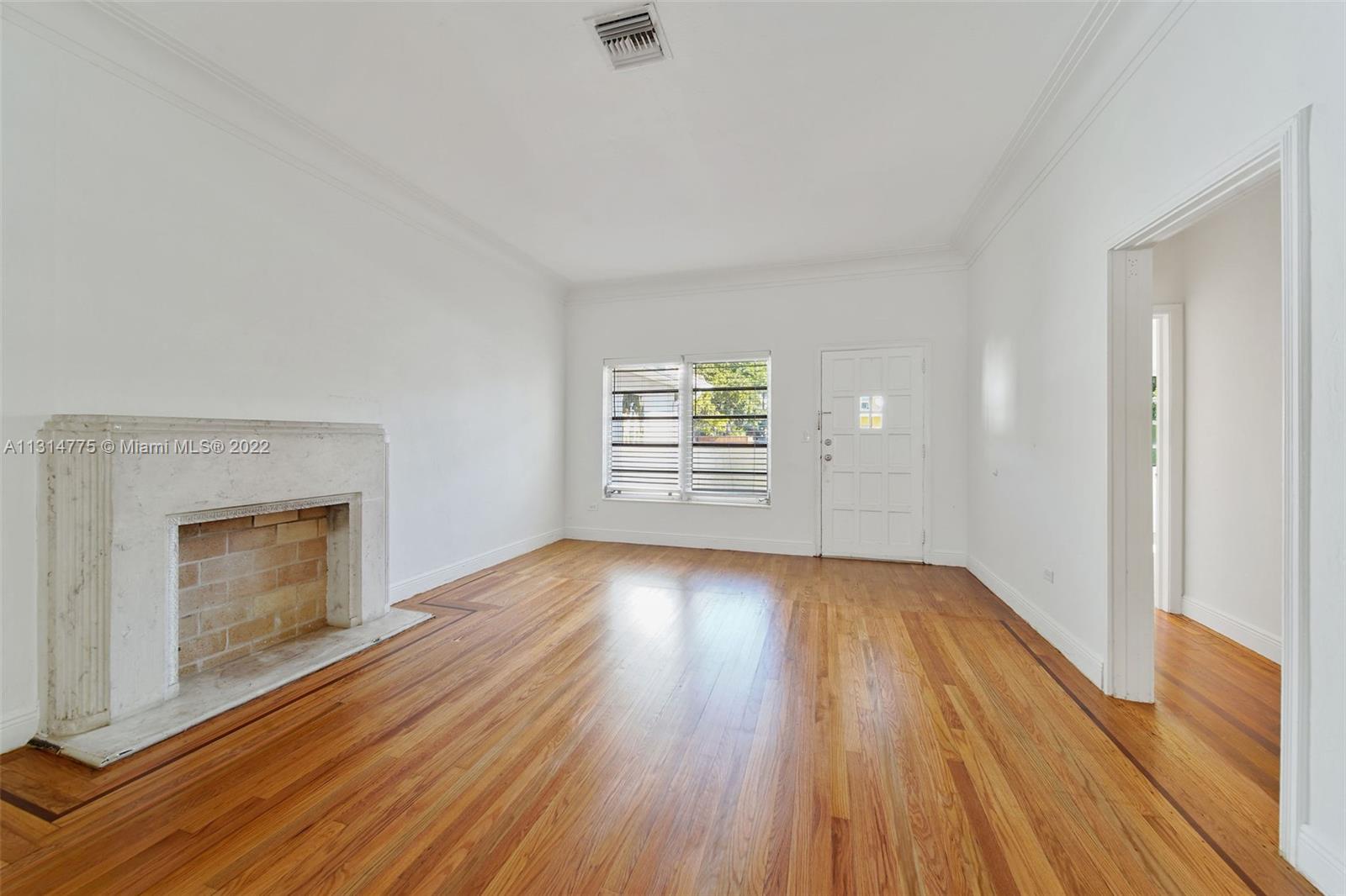 9116 Abbott Avenue Surfside, FL 33154 - Photo 7 of 23 an empty room with wooden floor fireplace and windows