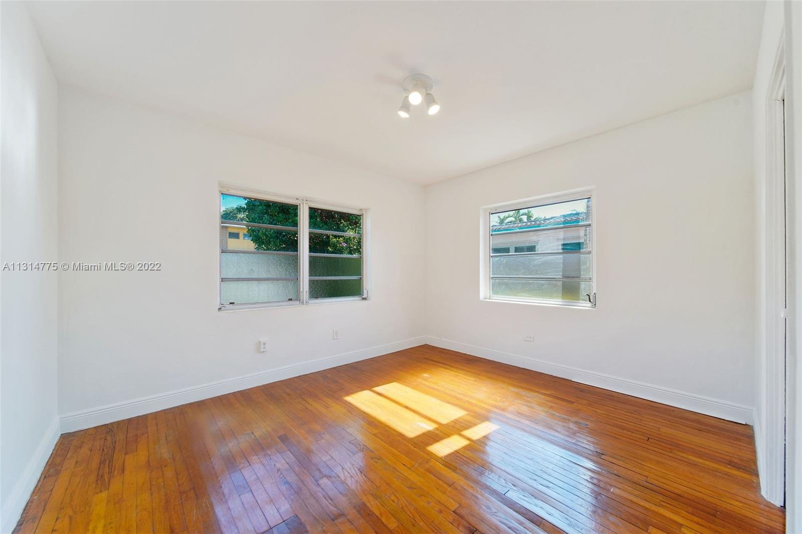 9116 Abbott Avenue Surfside, FL 33154 - Photo 8 of 23 a view of empty room with wooden floor and fan