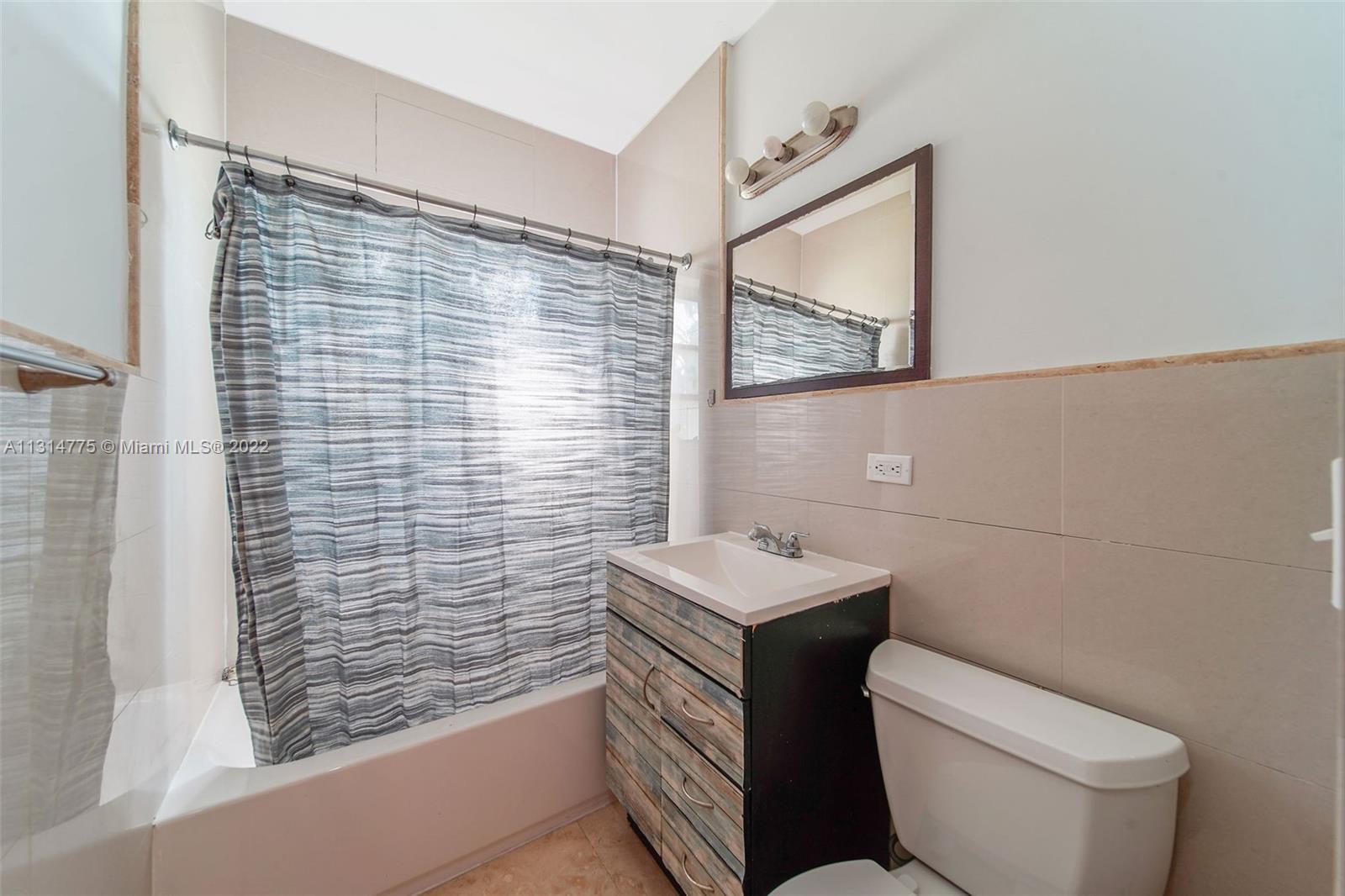 9116 Abbott Avenue Surfside, FL 33154 - Photo 9 of 23 a bathroom with a toilet sink and mirror