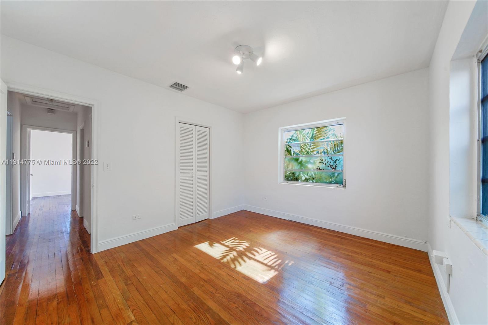 9116 Abbott Avenue Surfside, FL 33154 - Photo 10 of 23 an empty room with wooden floor and windows