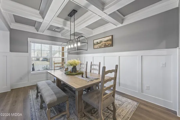 a dining room with furniture a chandelier and wooden floor