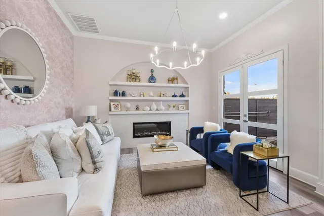 a living room with furniture a fireplace and a chandelier