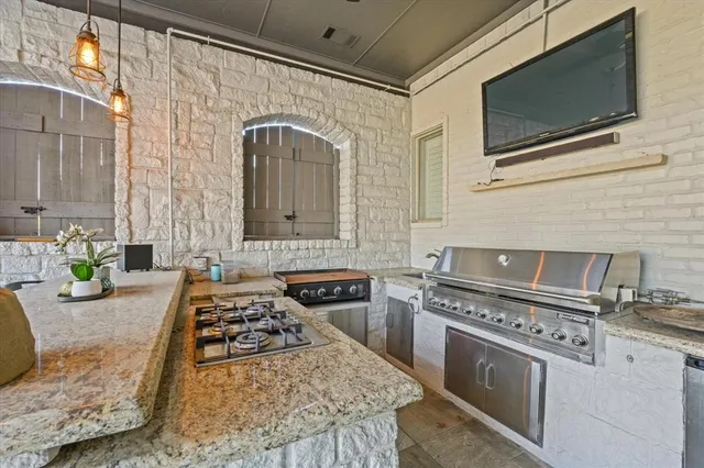 a kitchen with stainless steel appliances granite countertop a stove a sink and a microwave