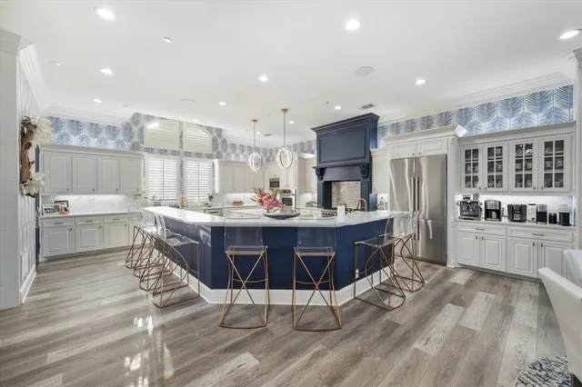 a kitchen with stainless steel appliances kitchen island granite countertop a stove a sink a refrigerator and cabinets