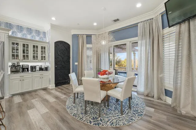a dining room with wooden floor and a chandelier