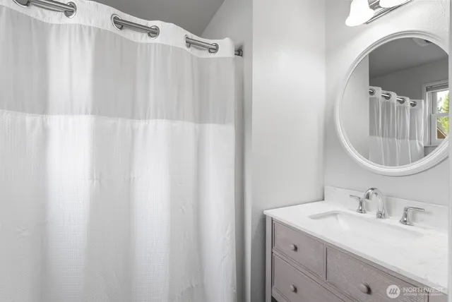 a bathroom with a sink vanity mirror and tub
