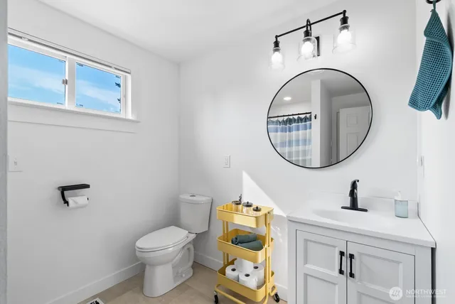 a bathroom with a toilet a sink and a mirror