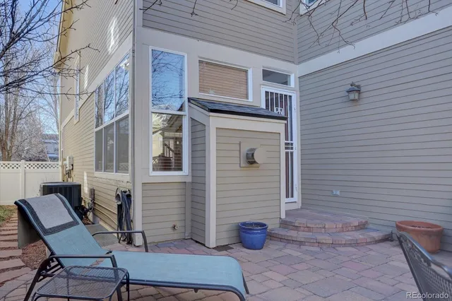 a view of a patio with table and chairs and wooden fence