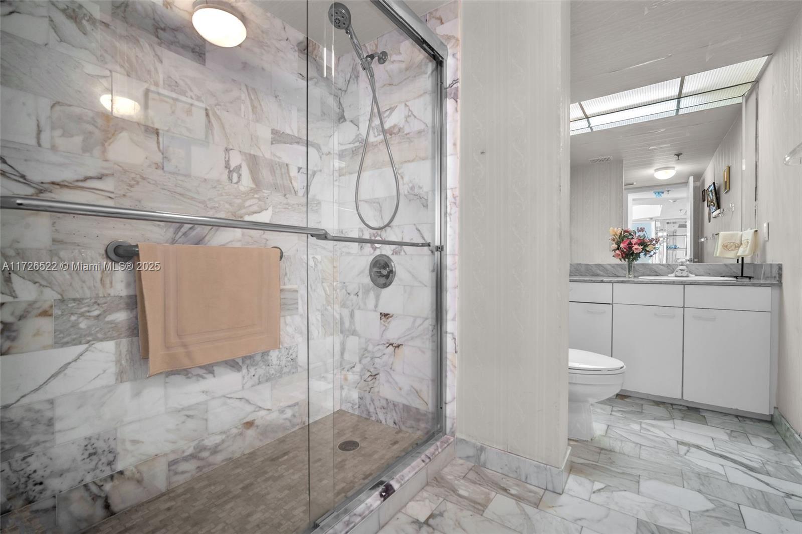 9341 Collins Avenue, Unit 1205 Surfside, FL 33154 - Photo 13 of 29 a bathroom with a toilet sink and shower