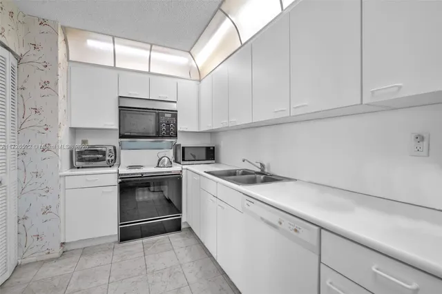 a kitchen with a sink appliances and cabinets