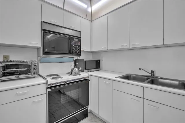 a kitchen with white cabinets appliances and sink