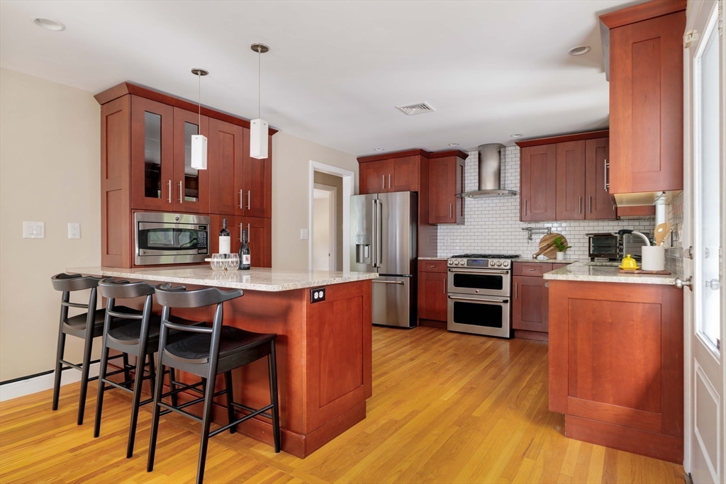 10 Hackensack Terrace Boston, MA 02467 - Photo 7 of 30 a kitchen with stainless steel appliances a stove a sink dishwasher and a refrigerator with wooden floor