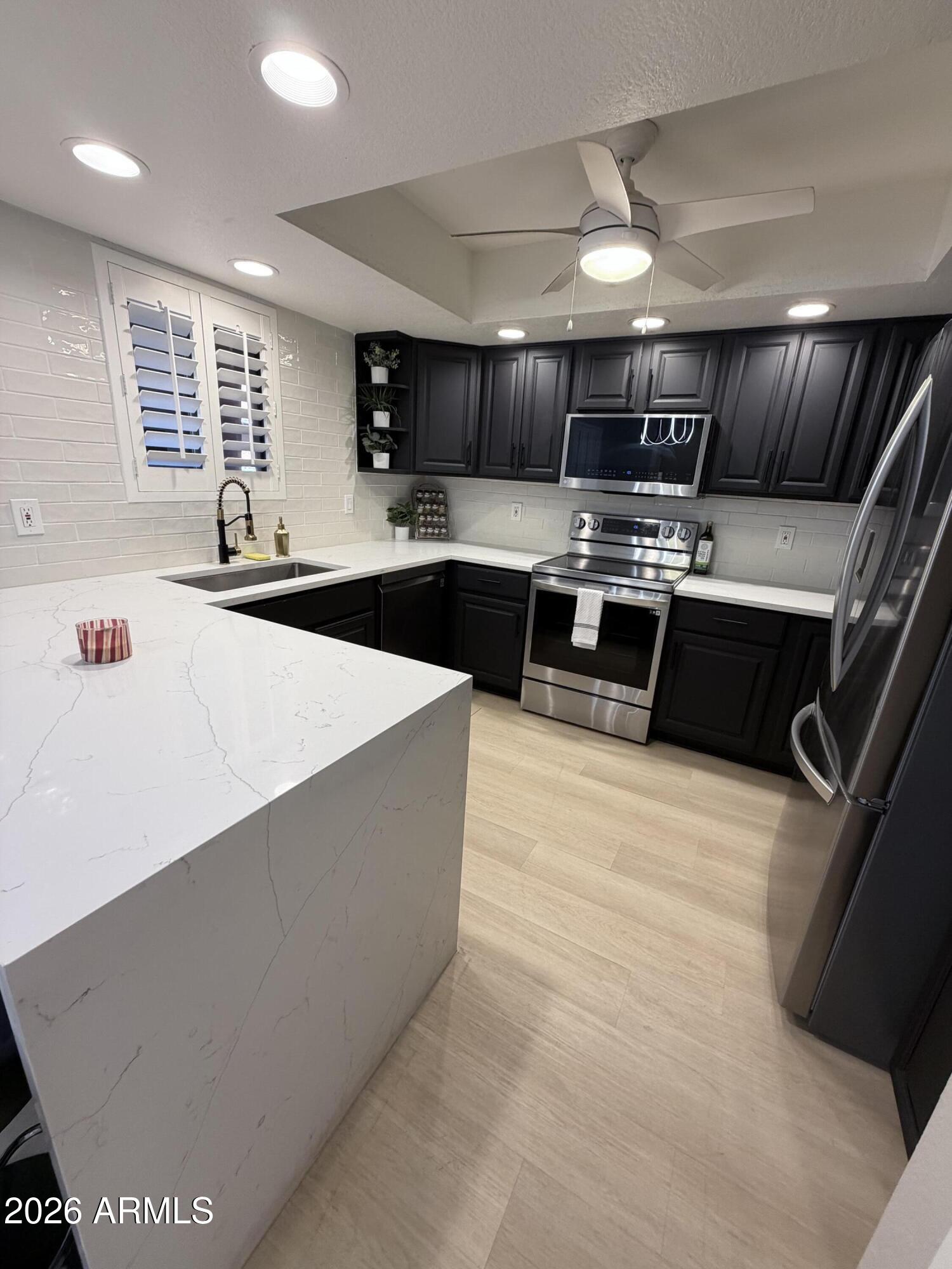 4303 East Cactus Road, Unit 128 Phoenix, AZ 85032 - Photo 34 of 39 a large kitchen with stainless steel appliances a large counter top
