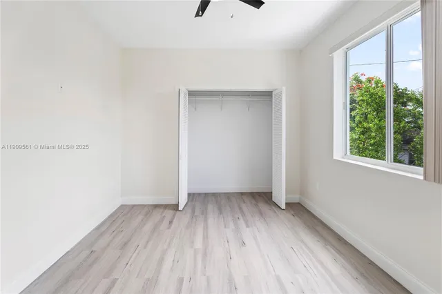an empty room with a window and wooden floor