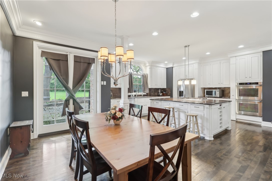 800 Merriman Road Akron, OH 44303 - Photo 12 of 42 Dining space featuring crown molding, a chandelier, dark wood finished floors, recessed lighting, and baseboards
