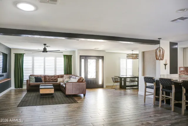 a kitchen with stainless steel appliances kitchen island granite countertop a table chairs and a refrigerator