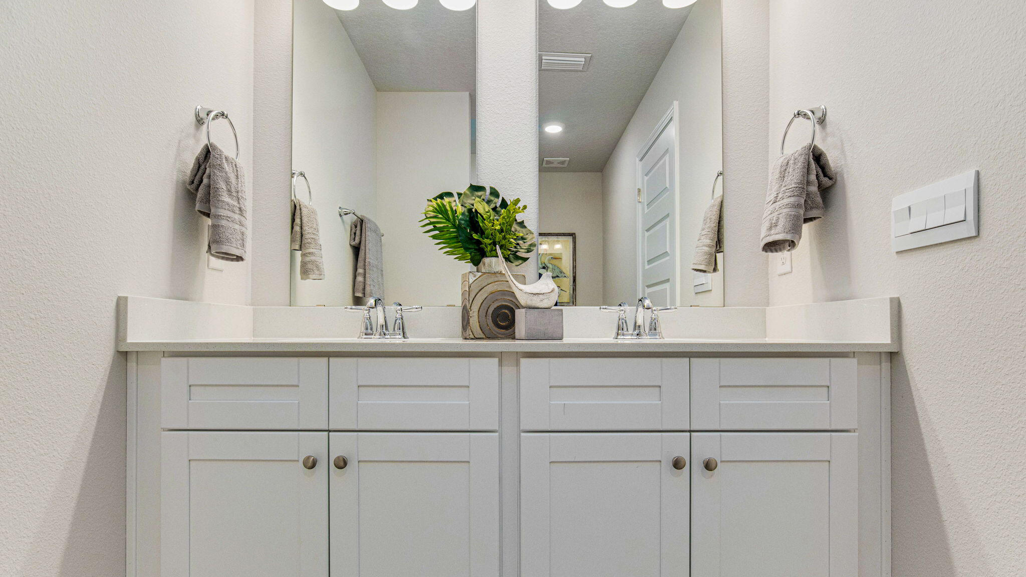 8513 Midtown Court Navarre, FL 32566 - Photo 19 of 27 a bathroom with a sink a potted plant and a mirror
