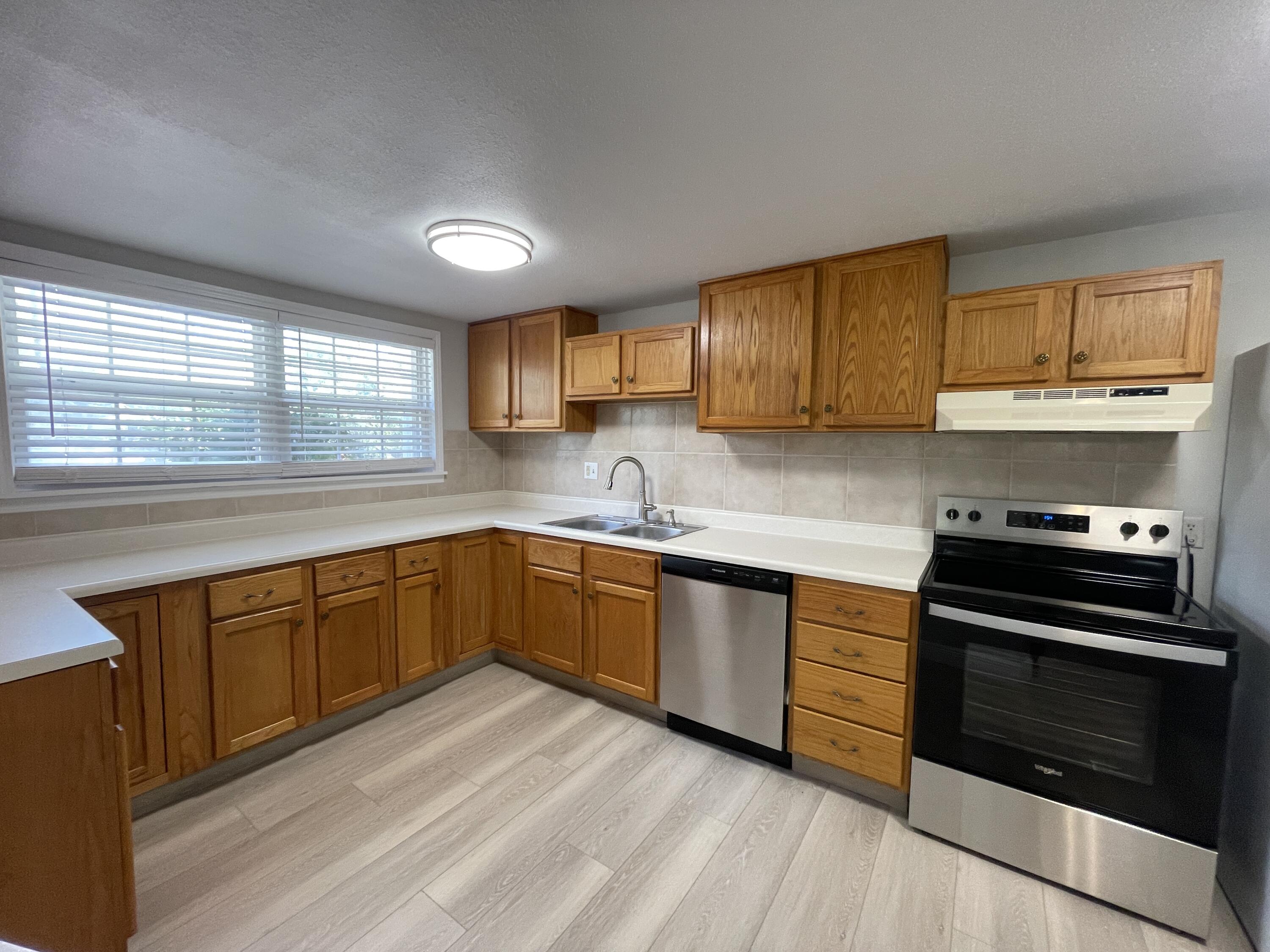 133 3rd Street, Unit B Niceville, FL 32578 - Photo 11 of 32 a kitchen with stainless steel appliances granite countertop a stove a sink and a microwave
