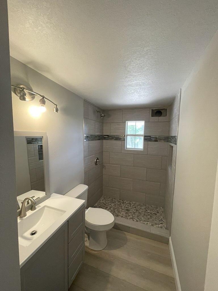 133 3rd Street, Unit B Niceville, FL 32578 - Photo 18 of 32 a bathroom with a toilet a sink and shower