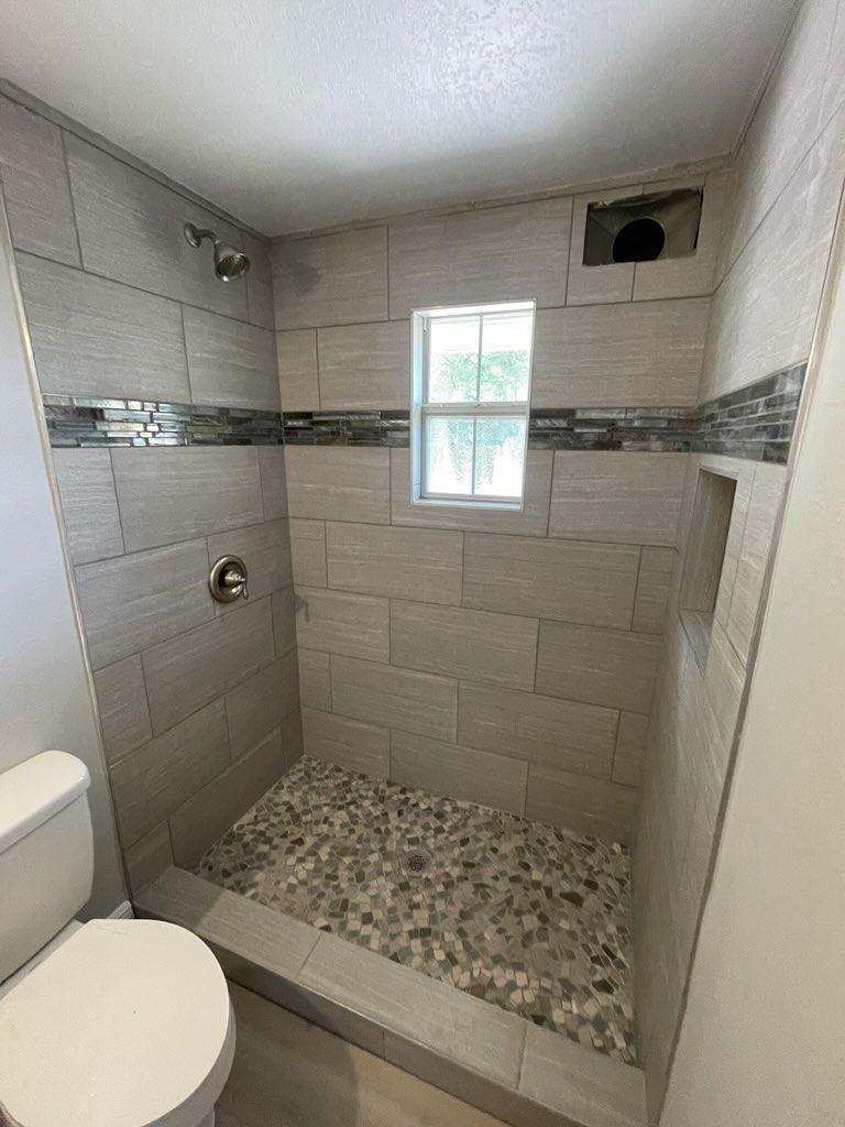 133 3rd Street, Unit B Niceville, FL 32578 - Photo 21 of 32 a bathroom with a toilet and shower