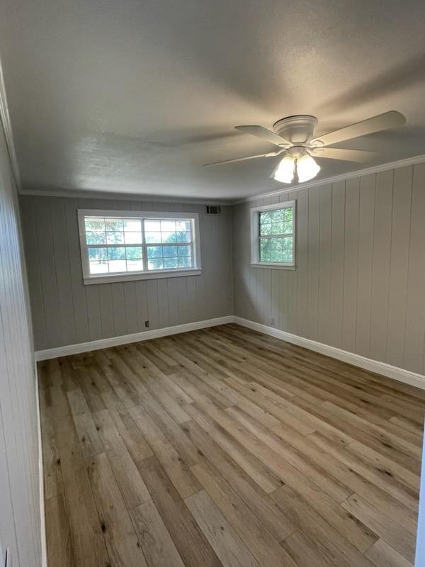 133 3rd Street, Unit B Niceville, FL 32578 - Photo 23 of 32 an empty room with wooden floor and windows
