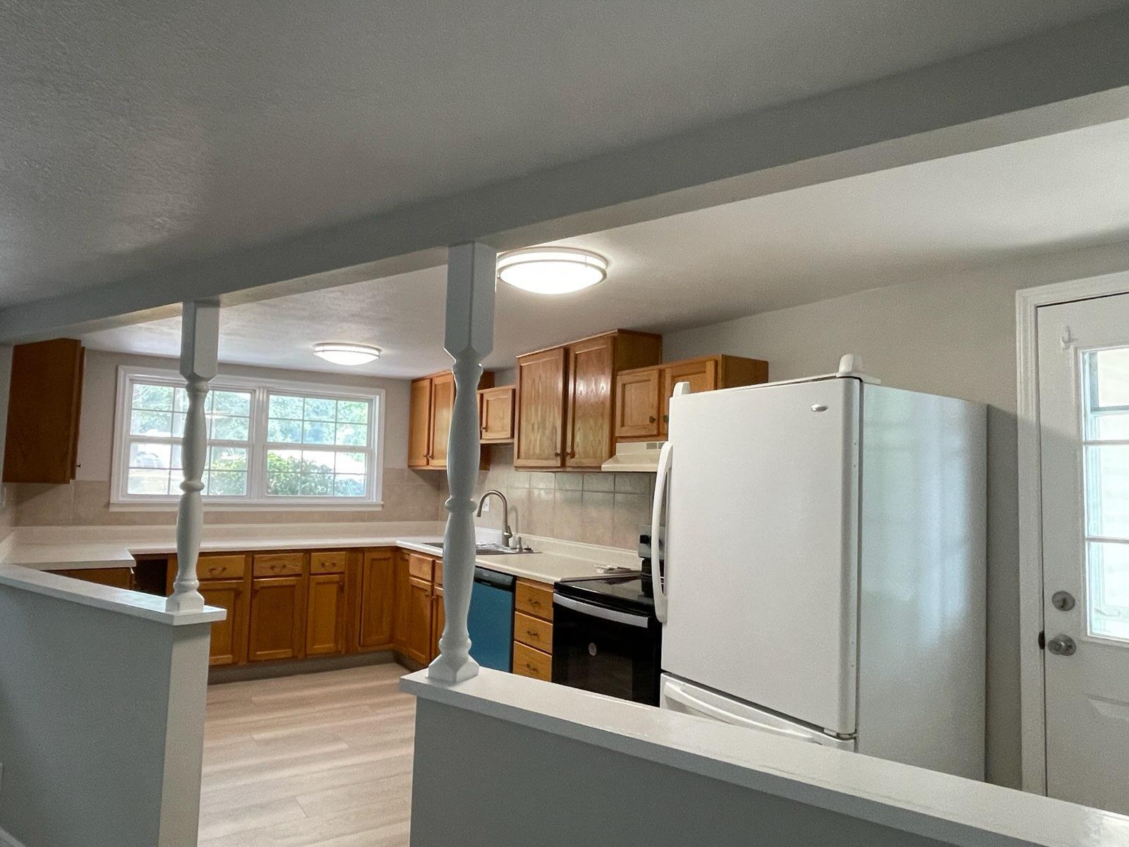 133 3rd Street, Unit B Niceville, FL 32578 - Photo 10 of 32 a kitchen with stainless steel appliances a refrigerator sink and cabinets