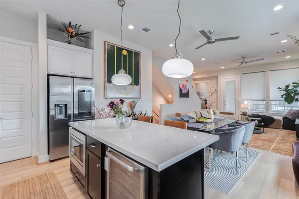 an open kitchen with a refrigerator a sink and a dining table