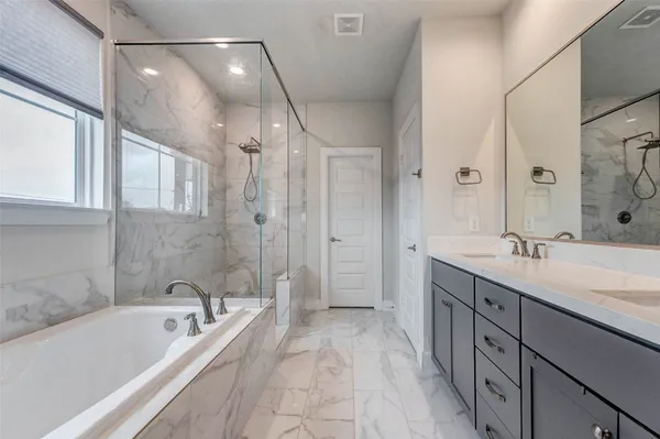a spacious bathroom with a tub sink shower and mirror