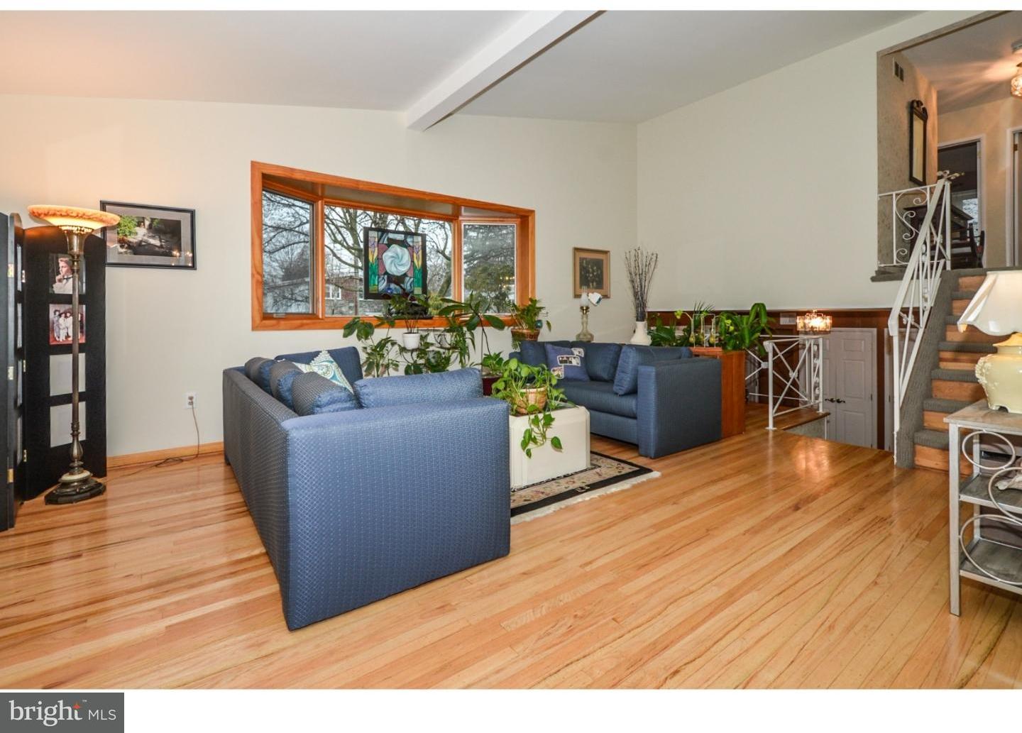 209 Radburn Road Philadelphia, PA 19115 - Photo 14 of 24 a living room with furniture a flat screen tv and a floor to ceiling window