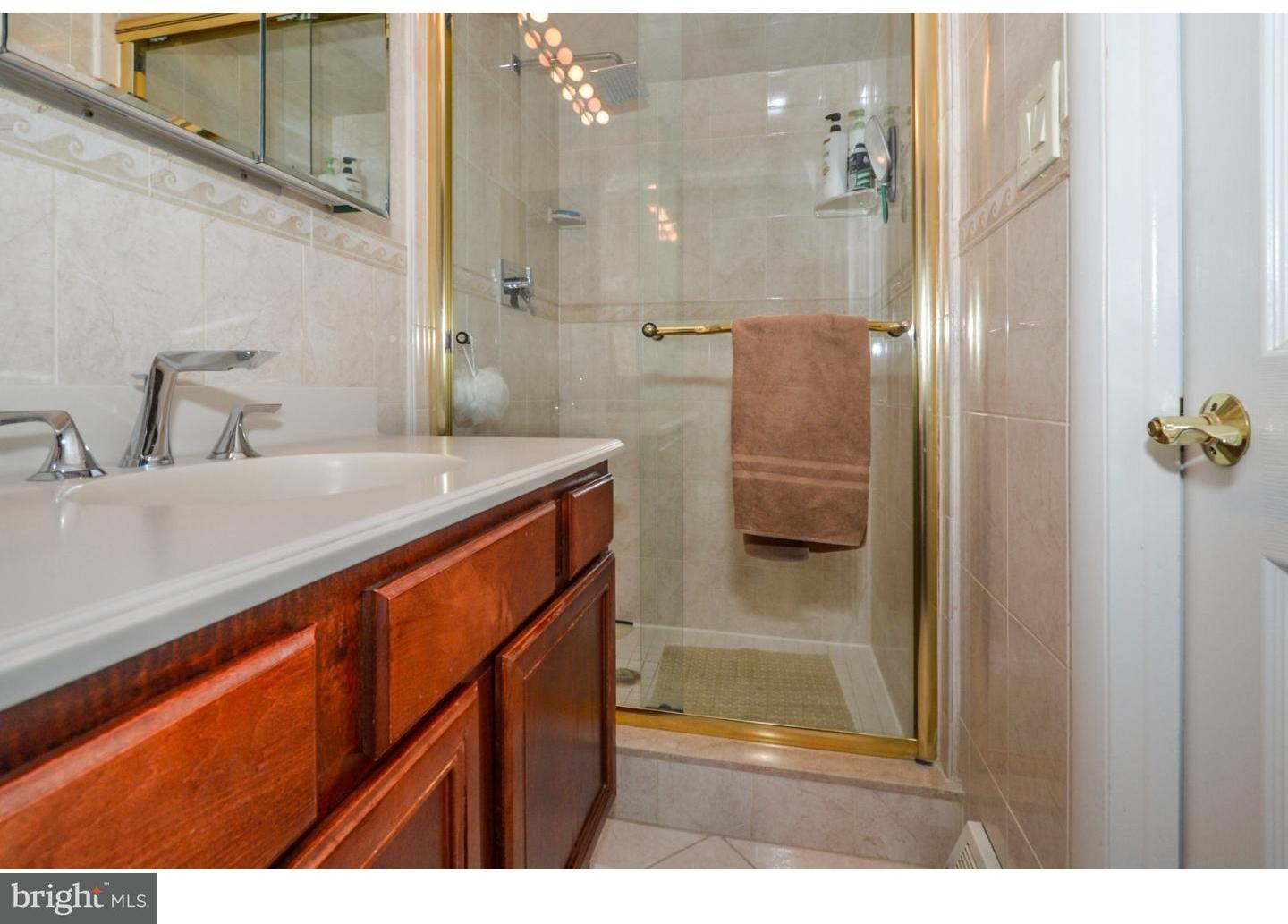 209 Radburn Road Philadelphia, PA 19115 - Photo 18 of 24 a bathroom with a shower sink and mirror