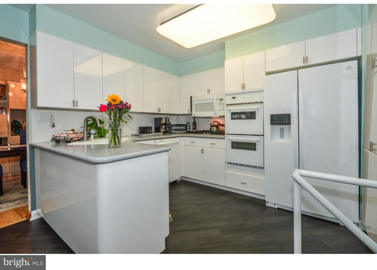 209 Radburn Road Philadelphia, PA 19115 - Photo 8 of 24 a kitchen with kitchen island white cabinets and white appliances