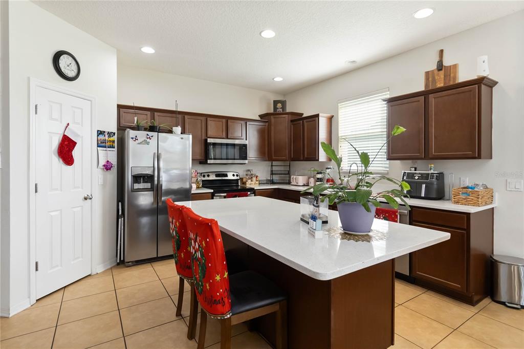 4042 Eternity Circle St. Cloud, FL 34772 - Photo 11 of 35 a kitchen with a refrigerator a microwave a sink and a stove